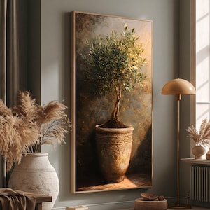 May include: A framed vertical canvas art print featuring an olive tree in a decorative pot. The artwork has a warm color palette with a detailed depiction of the tree and pot. The background has a textured, aged appearance.