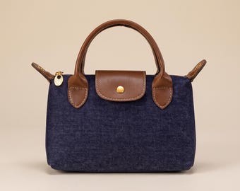 Bolsa mini jeans, carteira com detalhes em couro marrom, bolsa transversal estruturada com alça superior.