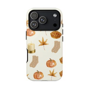 May include: A smartphone case with a cream-colored background featuring a repeating watercolor pattern of orange pumpkins, brown maple leaves, a lit candle in a gold holder, a pair of tan knit socks, and a small round pie with a lattice crust.