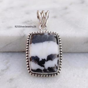 May include: A rectangular pendant featuring a white and black patterned stone set in a sterling silver frame with a beaded border and a decorative twisted bail. The text 925SilverJewelry26 is visible in the upper left corner of the image.