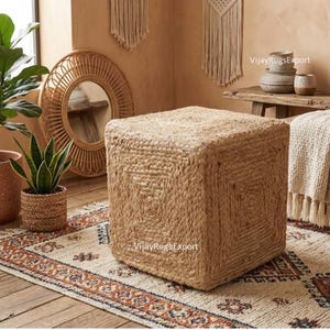 May include: A white ceramic mug with a black handle and the text "But First, Coffee" in a black, handwritten-style font. The mug is on a white surface.