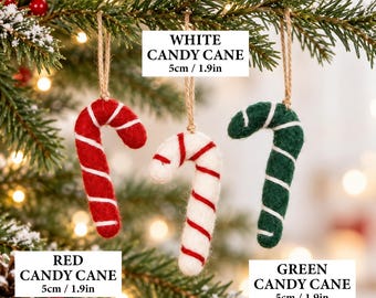 May include: Three felt candy cane ornaments hanging from twine loops. One is red with white stripes, one is white with red stripes, and one is green with white stripes. Each measures 5cm or 1.9 inches in height as labeled in the image.