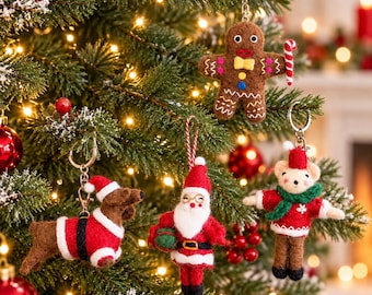 May include: Four felt ornaments hanging on a Christmas tree: a brown gingerbread person with a candy cane, a brown dachshund wearing a Santa suit, a Santa Claus figure with a white beard, and a bear wearing a red sweater and green scarf.