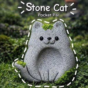 May include: A gray stone cat sculpture with the text "Stone Cat Pocket Pal". The cat has a textured surface, black eyes, and a small smile. Green moss accents the top and base of the sculpture, which is set in a grassy area.