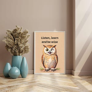 May include: Framed art print featuring a winking owl illustration with the text "Listen, learn and be wise." The owl is depicted in shades of brown, beige, and white, with a yellow eye. The print is displayed on a light brown background.