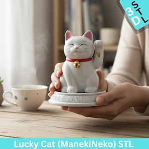 以下が含まれることがあります： 白いセラミック製の招き猫の置物。片方の前足を上げている。猫はピンク色の耳、赤い首輪に金色の鈴、笑顔の顔をしている。白い台座に乗り、ギリシャの鍵のデザインが施されている。下部には「Lucky Cat (ManekiNeko) STL」の文字。