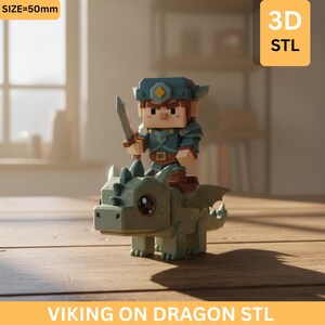 Op de afbeelding: Een 3D-geprint figuur van een Viking met een zwaard die op een groene draak rijdt. De Viking draagt blauwe bepantsering en een helm. De draak heeft vleugels en een blokkerige stijl. De tekst "VIKING ON DRAGON STL" staat onderaan.