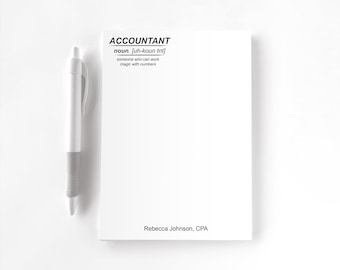 May include: A white notepad and a white pen. The notepad features the text ACCOUNTANT noun. [uh-koun tnt] someone who can work magic with numbers and the name Rebecca Johnson, CPA printed in black ink at the top and bottom respectively.