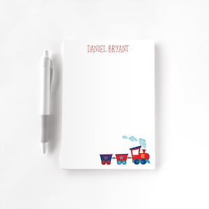 May include: A white notepad with red text that says "DANIEL BRYANT" at the top. The notepad has a red and blue cartoon train with white smoke at the top.