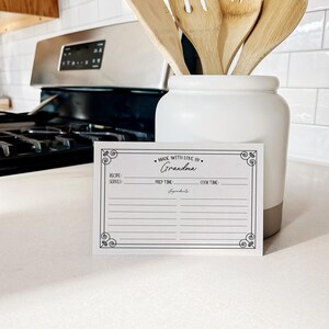 May include: A white recipe card with a black border and the text "Made with love by Grandma" at the top. The card has sections for the recipe name, servings, prep time, cook time, and ingredients.