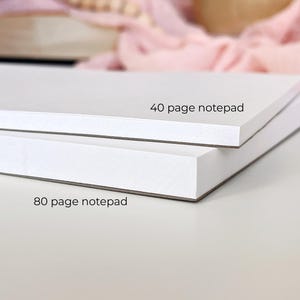 Pode incluir: Dois blocos de notas brancos empilhados. O bloco superior tem a etiqueta "40 page notepad", e o inferior "80 page notepad". Os blocos de notas s&atilde;o retangulares e t&ecirc;m um design limpo e minimalista.