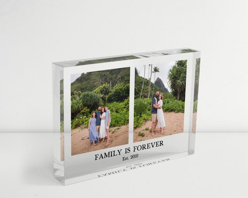 May include: A clear acrylic photo block with two family photos. The block has the text "FAMILY IS FOREVER Est. 2010" printed on the front. The photos show families in a tropical setting.