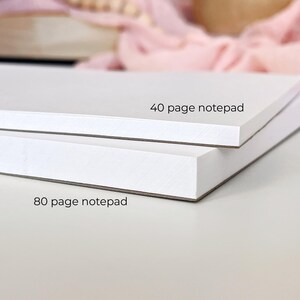 Puede incluir: Dos blocs de notas blancos apilados. El superior tiene la etiqueta "40 page notepad", y el inferior "80 page notepad". Los blocs de notas son rectangulares y tienen un dise&ntilde;o limpio y minimalista.