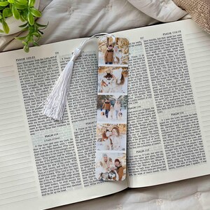 May include: A bookmark featuring a series of family photos. The bookmark has a white tassel and is placed on an open book with text from Psalm 109:21 and Psalm 110:10.