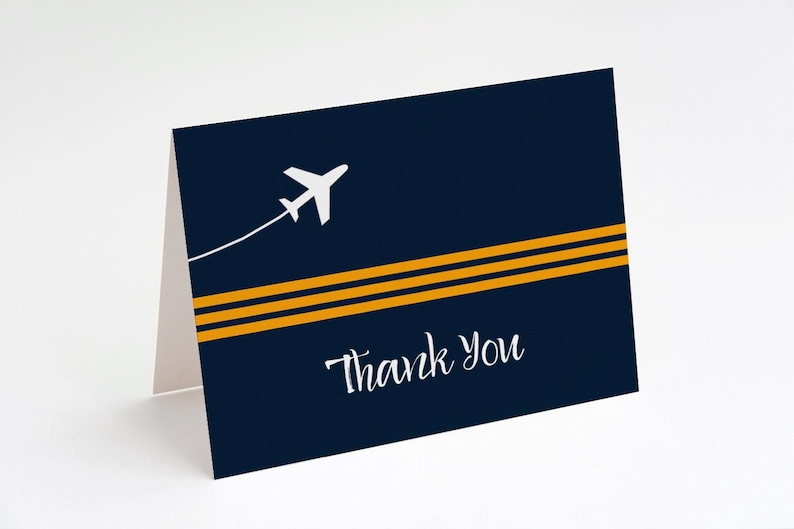 May include: A navy blue thank you card with two thin gold stripes and a white airplane flying above them. The text "Thank You" is written in white cursive.