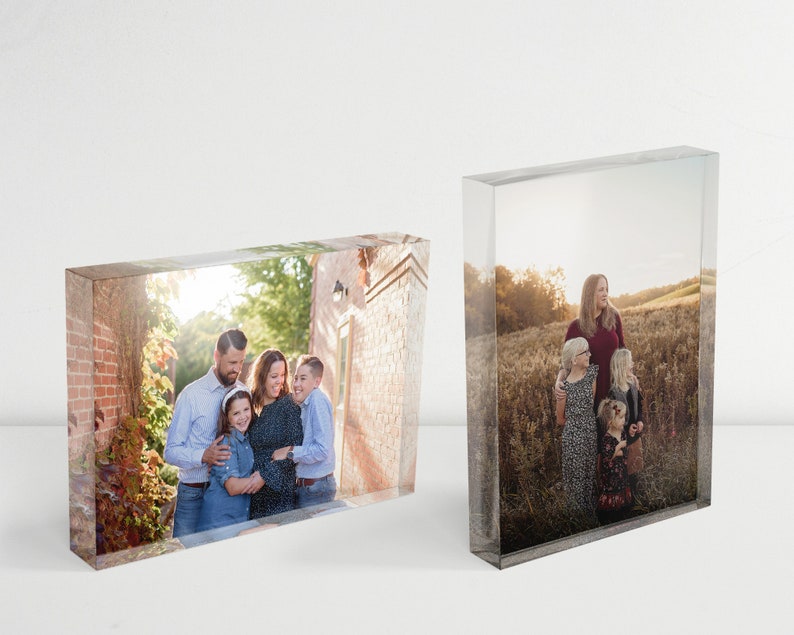 May include: Two glass photo blocks with images of families. The first block shows a family of four standing in a brick courtyard. The second block shows a family of three standing in a field.