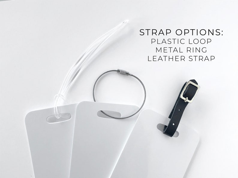 May include: White luggage tags with three strap options: a clear plastic loop, a gray metal ring, and a black leather strap. The text "STRAP OPTIONS: PLASTIC LOOP METAL RING LEATHER STRAP" is displayed.