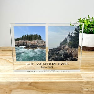 May include: A clear acrylic photo block with two landscape images of the Maine coast. The left image shows a rocky coastline with crashing waves, and the right image features a lighthouse. Text at the bottom reads "BEST. VACATION. EVER. Maine 2023."