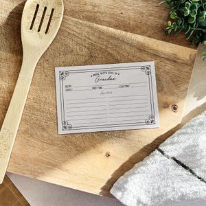 May include: A white recipe card with a black border and the text "Made with love by Grandma". The card has sections for recipe serves, prep time, cook time, and ingredients.