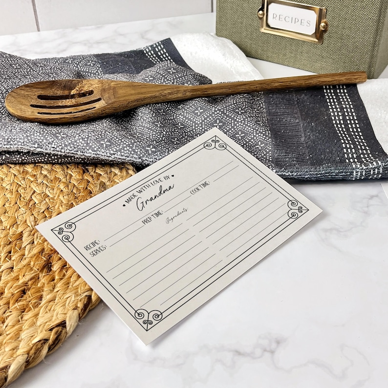 May include: A white recipe card with a black border and the text "Made with love by Grandma". The card has sections for recipe name, servings, prep time, cook time, ingredients, and signature.