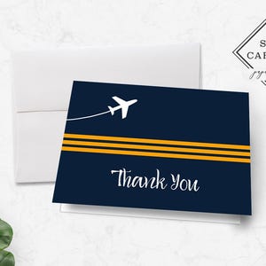 May include: A navy blue thank you card with a white airplane and three yellow stripes. The text "Thank You" is written in white cursive.