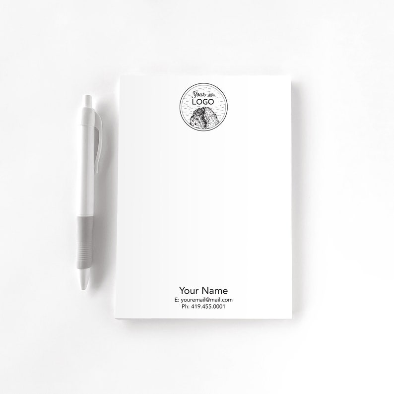 Op de afbeelding: Een wit notitieblok met een zwart-wit logo dat "Your Logo" zegt en contactgegevens die "Your Name, E: youremail@mail.com, Ph: 419.455.0001" zeggen.