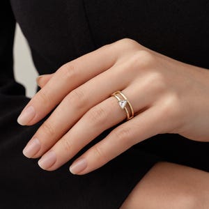 Puede incluir: Una taza de cerámica blanca con un asa negra y el texto "But First, Coffee" en negrita negra. La taza se encuentra sobre un fondo neutro, resaltando su diseño sencillo.