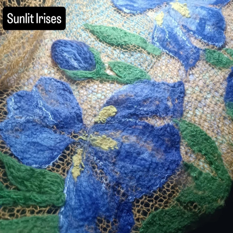 Pu&ograve; includere: Primo piano di un tessuto con fiori di iris blu, foglie verdi e dettagli gialli. Lo sfondo &egrave; un tessuto beige a trama aperta. Il testo "Sunlit Irises" &egrave; in un rettangolo nero in alto a sinistra.