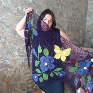 Pu&ograve; includere: Uno scialle blu scuro con disegni floreali e a farfalla. Lo scialle presenta grandi fiori blu con foglie verdi e una farfalla gialla. Lo scialle &egrave; realizzato in un materiale simile a una rete.