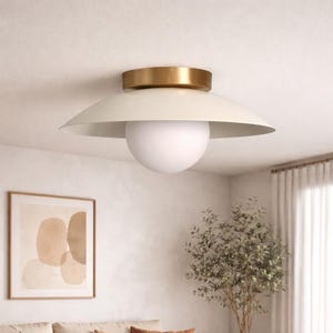 May include: A white ceramic mug with a black handle and the text "But First, Coffee" in a black, bold font. The mug is on a white surface.