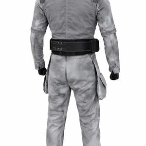 May include: A light gray jumpsuit with a mottled, weathered texture, featuring a high collar, long sleeves, and two side pockets on the thighs. A wide black utility belt with visible stitching and metal eyelets is fastened around the waist.