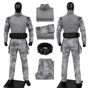 May include: A gray mottled long-sleeve jumpsuit with a high collar, shoulder patches, and side pockets. The set includes a black utility belt with multiple pouches, a folded gray top, folded gray pants, and a coiled black belt with a metal buckle.