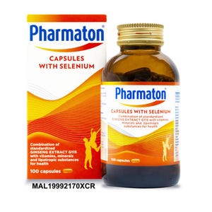 Puede incluir: Una caja y una botella de vidrio marrón de cápsulas Pharmaton. La caja es blanca y naranja con el nombre de la marca y "CAPSULES WITH SELENIUM" en negrita. La botella también muestra el nombre de la marca y la información del producto. El texto "100 cápsulas" es visible.