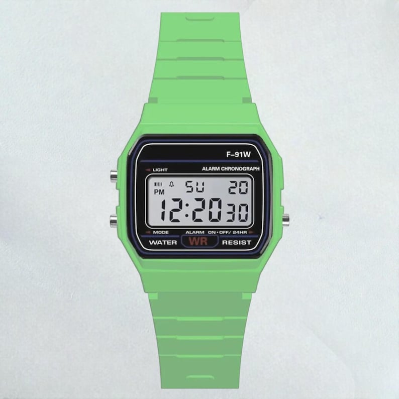May include: A digital watch with a green band and case. The watch face displays the time, day, and date. The watch has the text "F-91W" and other function labels. The watch is water resistant.