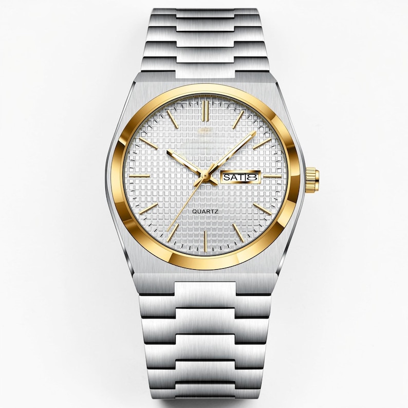 May include: A silver-toned quartz watch with a gold-colored bezel and hands. The watch face is white with a grid pattern and displays the day of the week. The watch has a silver-toned metal band.