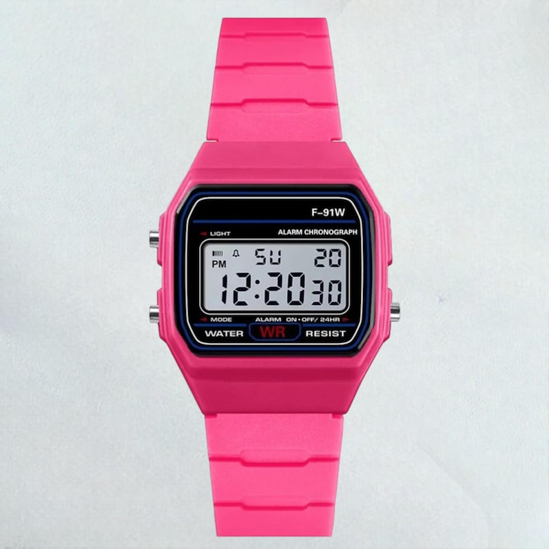 May include: A bright pink digital watch with a black display screen. The watch face displays the time, day, and date. The watch has a pink band and is labeled "F-91W".