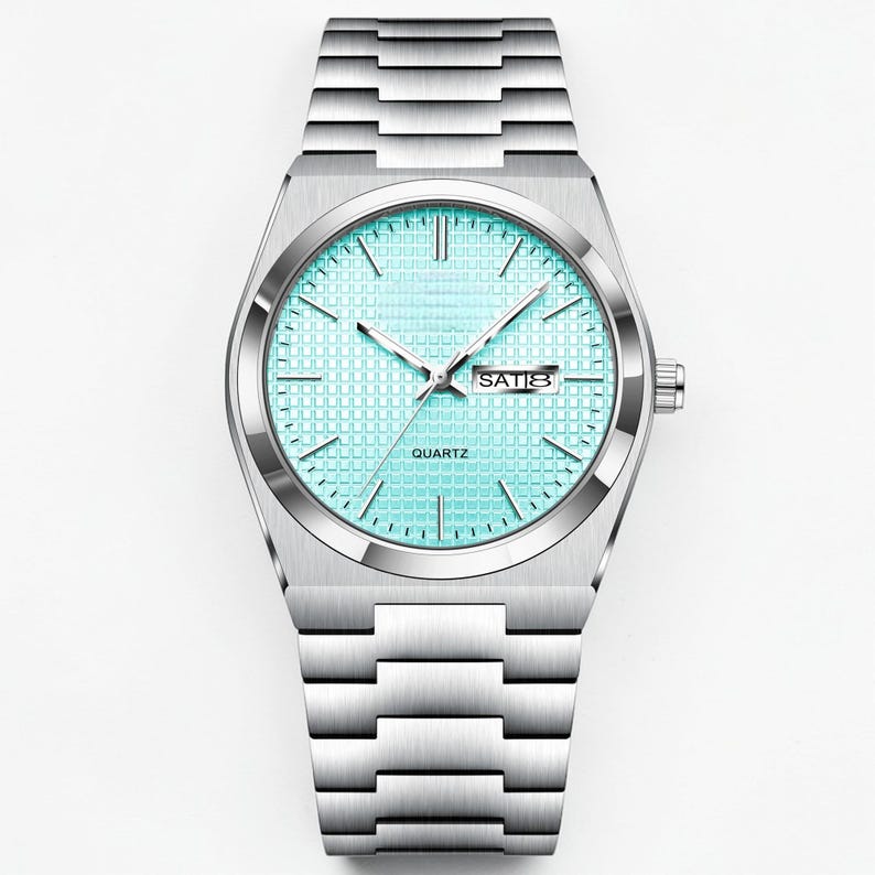 May include: A silver-toned quartz watch with a light blue face and a matching silver band. The watch face displays the day of the week and the word "QUARTZ". The watch has a rectangular case and a link-style band.