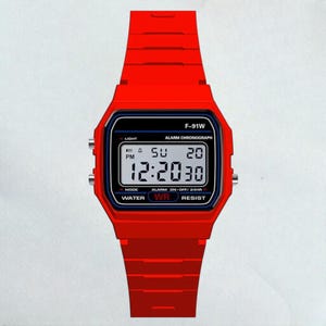 May include: A bright red digital watch with a rectangular black display. The watch face shows the time, day, and date. The watch band and case are also red. The watch has the text "F-91W" and "WATER WR RESIST".