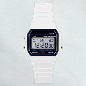 May include: White digital watch with a rectangular face and a white strap. The watch face displays the time, day, and date. The watch has the text "F-91W" and "ALARM CHRONOGRAPH". The watch is water resistant.