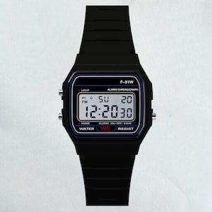 May include: Black digital watch with a rectangular face and matching black band. The watch face displays the time, day, and date in white digits against a black background with blue accents. The watch has the text "F-91W" at the top.