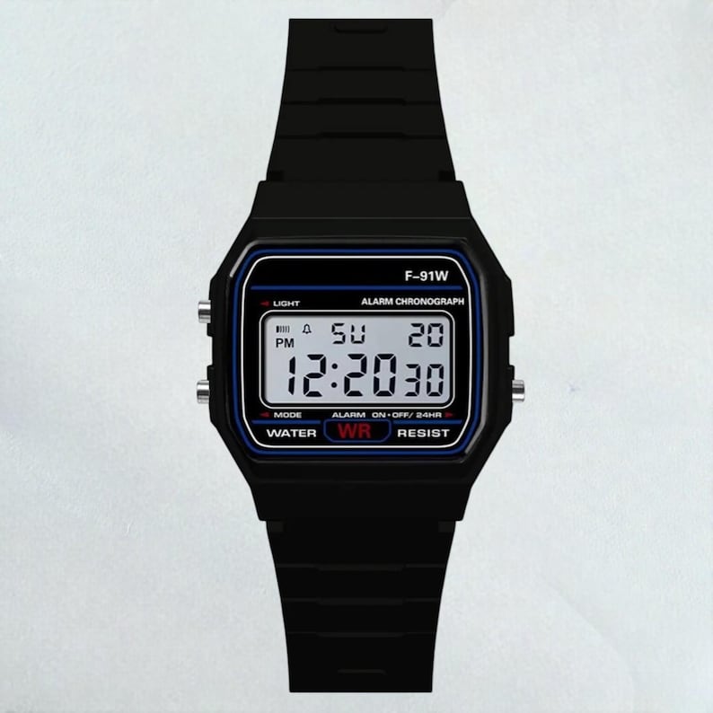 May include: Black digital watch with a rectangular face and matching black band. The watch face displays the time, day, and date in white digits against a black background with blue accents. The watch has the text "F-91W" at the top.