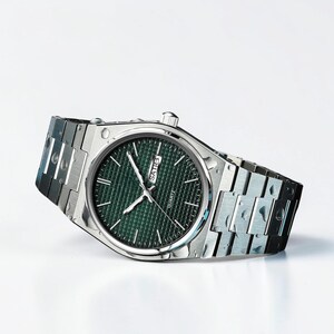 May include: A silver-toned quartz watch with a green textured dial. The watch features silver hands and markers, and a date display. The watchband is a silver link style.