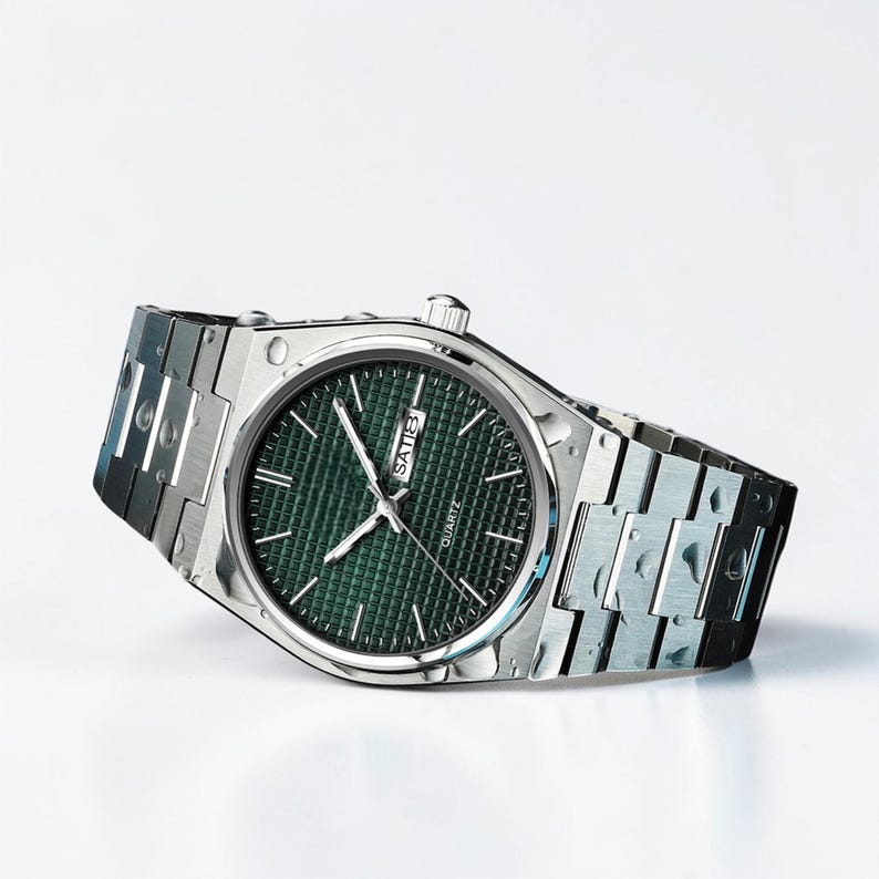May include: A silver-toned quartz watch with a green textured dial. The watch features silver hands and markers, and a date display. The watchband is a silver link style.