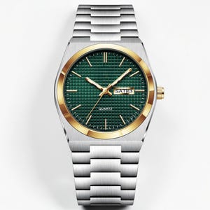 May include: A silver-toned quartz watch with a gold-colored bezel and a green textured dial. The watch features gold-colored hands and hour markers, with the day and date displayed at the 3 o'clock position. The watch band is made of silver-toned metal.