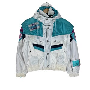May include: A white, teal, and black hooded jacket featuring multiple patches, including one that reads World Championship Leyton House. The jacket has a front button closure, two chest pockets, and elastic cuffs and hem for a secure fit.