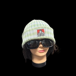 May include: A light green and white striped knit beanie with a Ben Davis patch. The patch features a red and white logo. The beanie is worn with black sunglasses on a mannequin head.