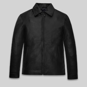 May include: A black leather jacket with a collared neckline and a full-length zipper closure. The jacket has long sleeves and two front pockets. The garment is displayed against a light gray background.