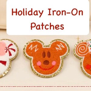 May include: Three embroidered iron-on patches featuring holiday-themed character shapes with gold glitter borders. The left patch is white with a pink bow and red peppermint swirls. The center and right patches are brown gingerbread-style faces.