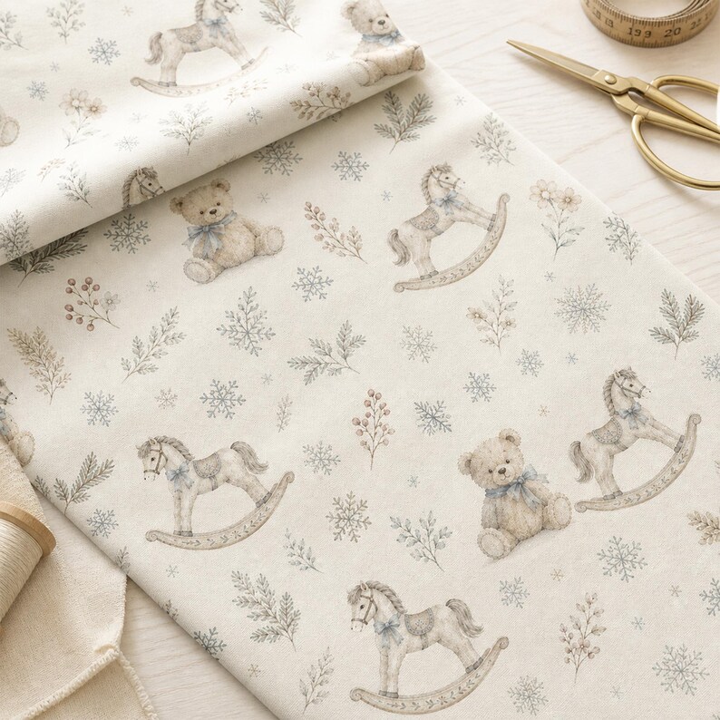 May include: A cream-coloured fabric featuring a repeating pattern of light brown teddy bears with blue bows, rocking horses, snowflakes, and sprigs of greenery. The textile is displayed with gold-toned scissors and a measuring tape nearby.