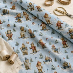 May include: A light blue fabric featuring a repeating pattern of brown teddy bears skiing and wearing winter sweaters, hats, and scarves. The print includes small green pine trees, red and blue flags, and gift boxes scattered across the snowy scene.